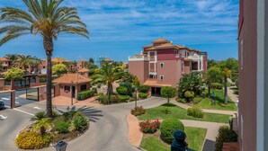 A residential area with a large building, palm trees, and a well-maintained lawn. - Prado Golf - Isla Canela Golf GPHG45P86 (Isla Canela)