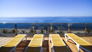 A balcony with sun loungers overlooking a beach. - SOLUXE Apartment - Only Families - Beachfront (Salou)
