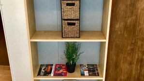 A bookshelf with a 'Relax' sign, a potted plant, and various books and magazines.
