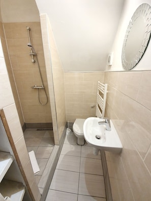 A bathroom with a shower, toilet, and sink.