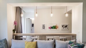 Un salon moderne comprenant un canapé, une table basse et un coin repas avec des chaises.