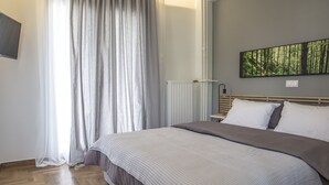 Une chambre à coucher avec un lit, un radiateur, une fenêtre avec des rideaux et un tableau accroché au mur.