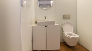A small, modern bathroom with a white sink, mirror, and toilet. - The Brewmaster's House 2 | Studio Deluxe (Porto)