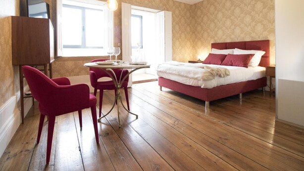 A bedroom with a bed, a table with chairs, and a TV on a stand. - The Brewmaster's House 2 | Studio Deluxe (Porto)