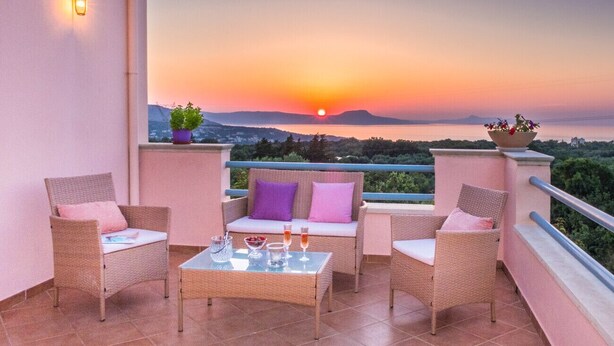 A balcony with wicker furniture, a glass table with drinks, and a sunset view. - Private villa with unique panoramic sea views, pool, bbq, 3km to the beach! (Prines)
