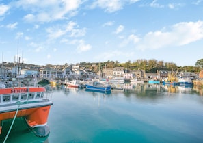 Boats moor in the calm waters of a picturesque harbor surrounded by buildings.