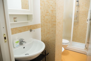 A bathroom with a sink, toilet, and shower. - Casa Bella Marconi is an Apartment of 34 Square Meters. Clean, Bright, in the Heart of the City (Bologna)