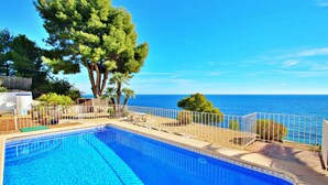 A swimming pool with a view of the sea, surrounded by trees and a white fence. - Celia - oceanfront villa in Costa Blanca (Benissa)