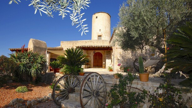 A rustic building with a stone facade, a wooden door, and a large wheel. - Lovely Villa with swimming pool, BBQ, Wifi, Terrace, Patio, Garden, Fireplace,  (Porreres)