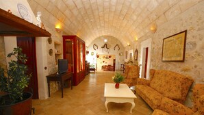 A spacious living area with a high arched ceiling, a sofa, a coffee table, and a television. - Lovely Villa with swimming pool, BBQ, Wifi, Terrace, Patio, Garden, Fireplace,  (Porreres)