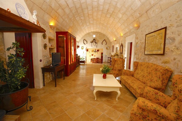 A spacious living area with a high arched ceiling, a sofa, a coffee table, and a television. - Lovely Villa with swimming pool, BBQ, Wifi, Terrace, Patio, Garden, Fireplace, (Porreres)
