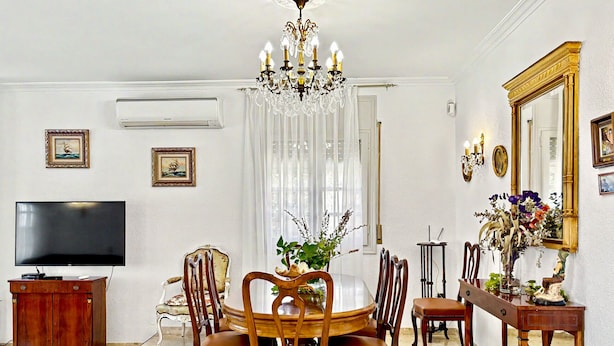 A dining area with a chandelier, a television, and a mirror. - NAPOLEON Villa piscina privada, BBQ, Wifi gratis (Miami Playa)