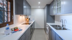 A modern kitchen with grey cabinets, a built-in oven, a washing machine, and a sink. - Playa Verde - Punta del Moral Beach PPHV31P26 (Punta del Moral)