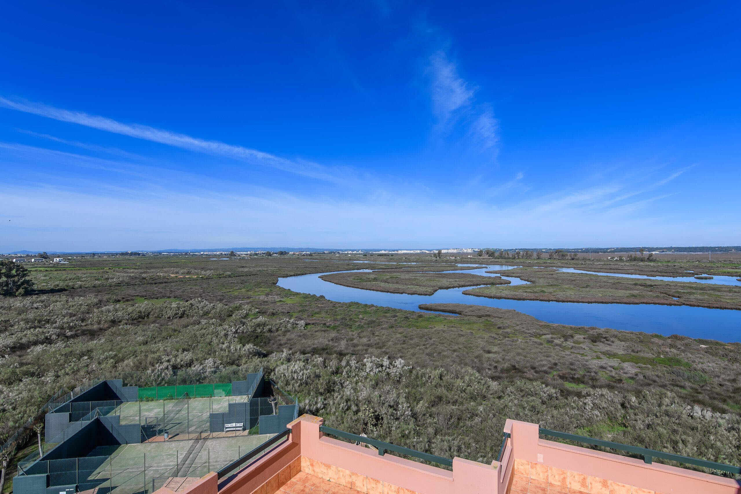 A view of a coastal landscape with a series of water channels and a distant shoreline.