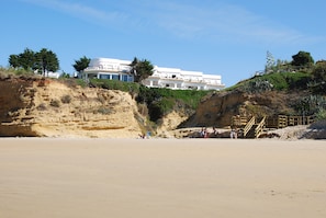 A coastal hotel with a beach view, a wooden staircase, and a cliffside location. - Apartment with beautiful sea views, Villa Fuente del Gallo 2 bedrooms (Conil de la Frontera)