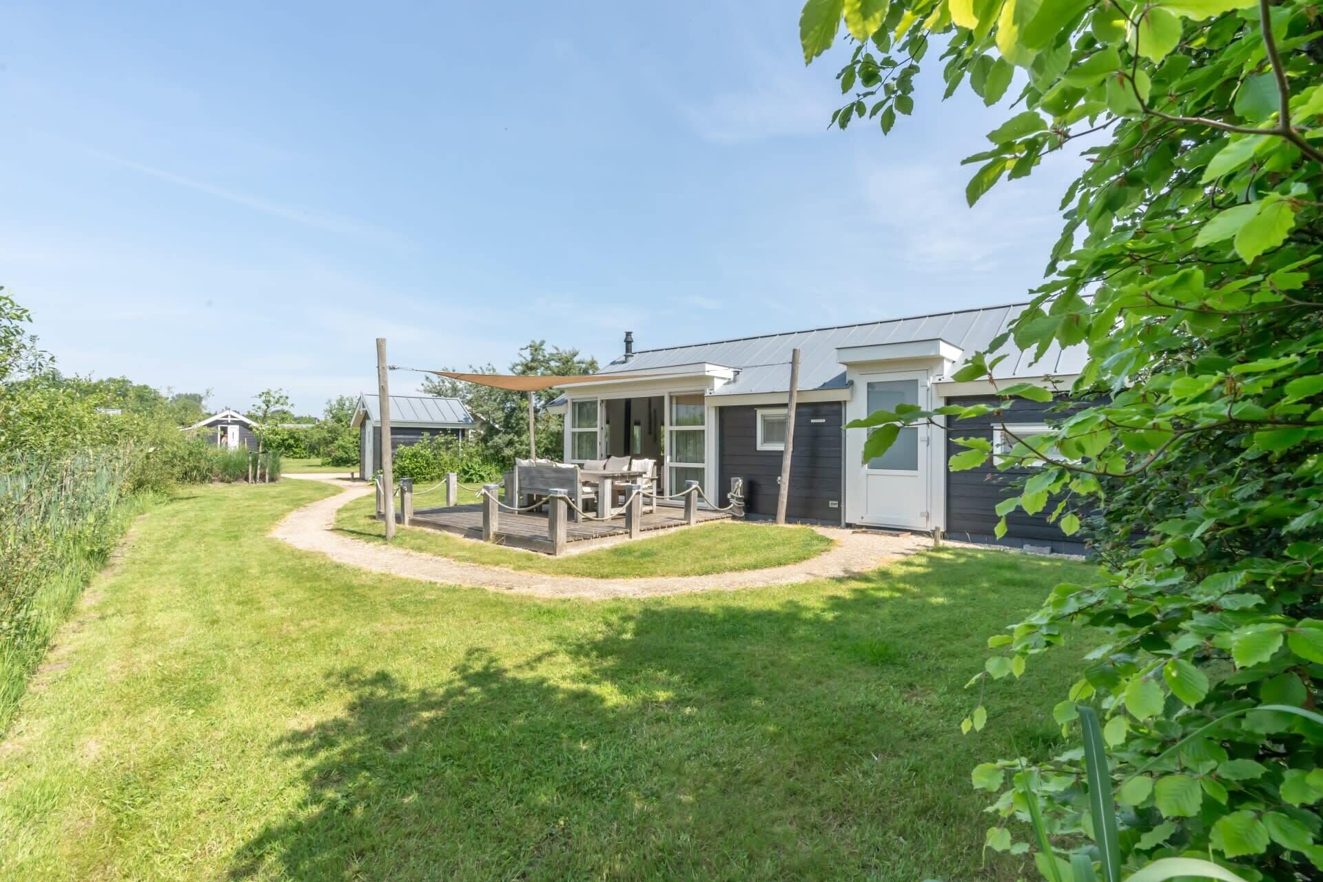 Una propiedad residencial con un patio, un área de estar al aire libre techada y un cobertizo pequeño.