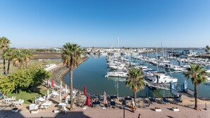 Un port de plaisance avec des bateaux, des palmiers et des espaces de détente en plein air.