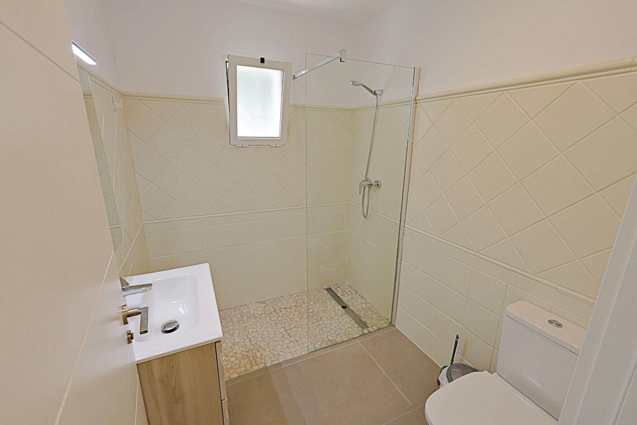 A bathroom with a shower, toilet, and sink.