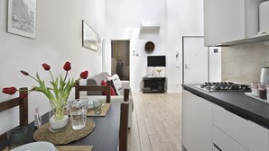 Una cucina moderna con zona pranzo, pareti bianche e vista sul soggiorno.