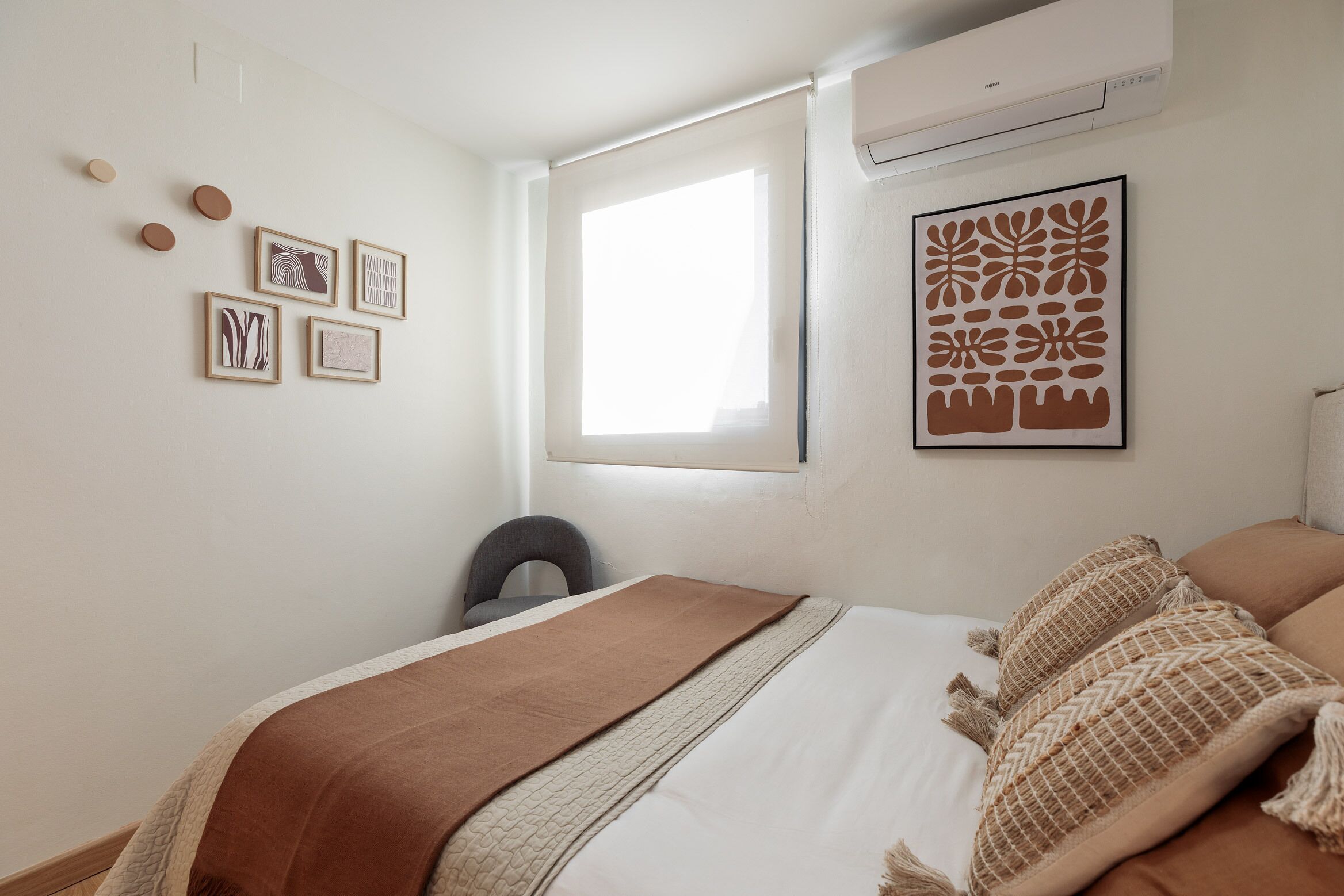 Un dormitorio con cama, ventana y decoración en la pared.