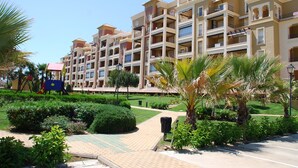 A multi-story hotel with balconies, a playground, and well-maintained gardens. - Canela Park Penthouse - Isla Canela Beach ICHP249P183 (Isla Canela)