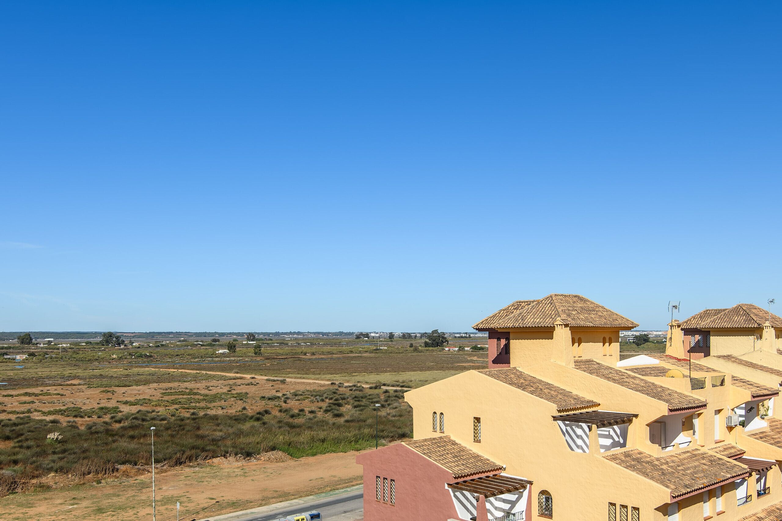 Een woonwijk met huizen met terracotta daken en een vlakke horizon.