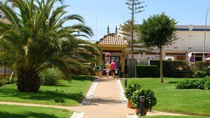A pathway leading to a building with a tiled roof and a gate. - Canela Park Penthouse - Isla Canela Beach ICHP249P183 (Isla Canela)