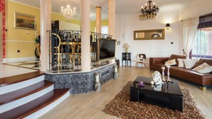 A spacious living room with a fireplace, a large TV, and a comfortable seating area. - Luxury Villa Antoneta with Swimming Pool (Šibenik)
