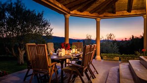An outdoor patio with a wooden table and chairs, surrounded by a pergola. - Luxury Villa Antoneta with Swimming Pool (Šibenik)