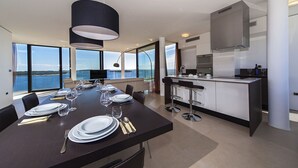 Una cocina moderna con una isla central, ventanas amplias y vista al mar.