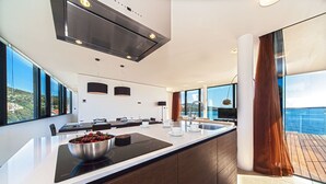 Una cocina moderna con una isla grande, un comedor y vistas al mar.