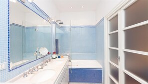 Een bad/douchecombinatie, een haardroger, een bidet, handdoeken