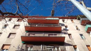 A multi-story building with balconies, windows, and a visible air conditioning unit. - Casa Bella Fair (Bologna)