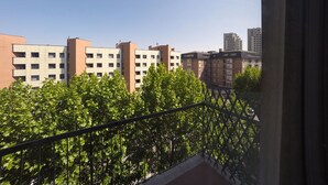 A balcony with a view of multi-story buildings and green trees. - Casa Bella Fair (Bologna)