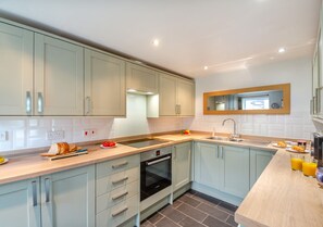 Enjoy cooking in this well-lit kitchen with an oven, stainless steel sink, and light cabinetry.
