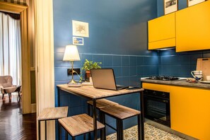 Work and dine in comfort with a compact kitchen featuring a table, stools, stove, and oven.