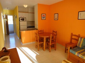 A compact living space with a kitchen, dining area, and a sofa.
