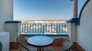 Un balcón con vista a un puerto deportivo y al paisaje urbano.