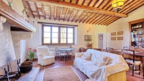 Una sala de estar acogedora con chimenea, un comedor y una estantería.
