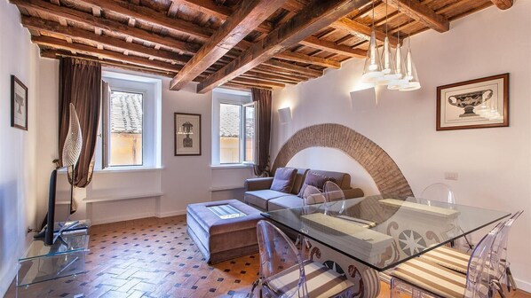 A cozy living room with a glass coffee table, a sofa, and a fireplace.