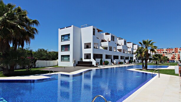 A modern hotel with a swimming pool, multiple balconies, and palm trees. - AL 230 - Apartment near the beach (Vera playa)