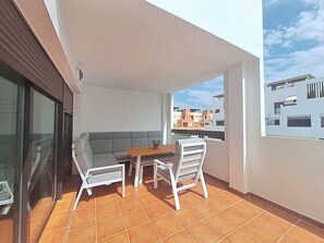 A balcony with a sofa, two chairs, a table, and a potted plant. - AL 230 - Apartment near the beach (Vera playa)