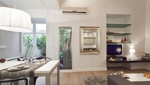Ein modernes Wohnzimmer mit Essbereich, Fernseher und Bücherregal.
