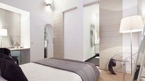 Ein modernes Schlafzimmer mit Bett, Schreibtisch, Stuhl und Spiegel.