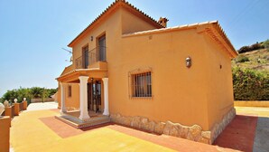 A two-story house with a balcony, a porch, and a stone foundation. - Marques - holiday home with private swimming pool in Benitachell (Benitachell)
