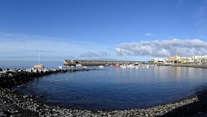 Une ville côtière dotée d’un port de plaisance, d’une côte rocheuse et de bâtiments qui se dressent à l’arrière-plan.