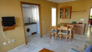 Un espacio habitable compacto con cocina, comedor y sofá.