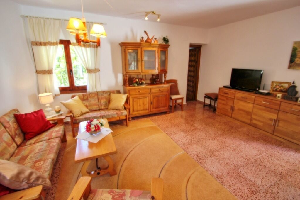A cozy living room with a sofa, coffee table, and wooden cabinet.