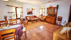 Una sala acogedora con muebles de madera, una mesa de comedor y un aparador.