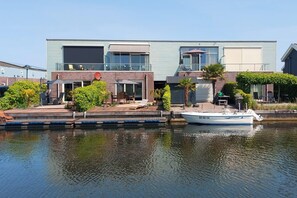 Ein modernes Gebäude mit einem Steg und einem Boot.